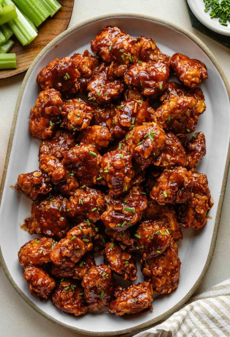 Crispy Air Fryer Honey BBQ Chicken Bites on a white platter, garnished with green onions.