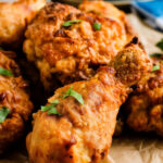 A plate of golden brown, extra crispy air fryer fried chicken thighs and drumsticks served with a side of coleslaw.
