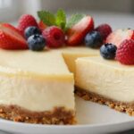 Easy homemade cheesecake with a buttery graham cracker crust and creamy filling topped with fresh strawberries, blueberries, and raspberries.